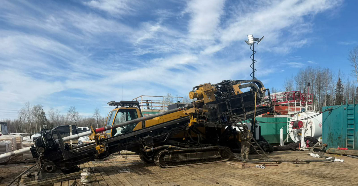 A directional drilling machine installs an underground pipeline at an industrial job site.